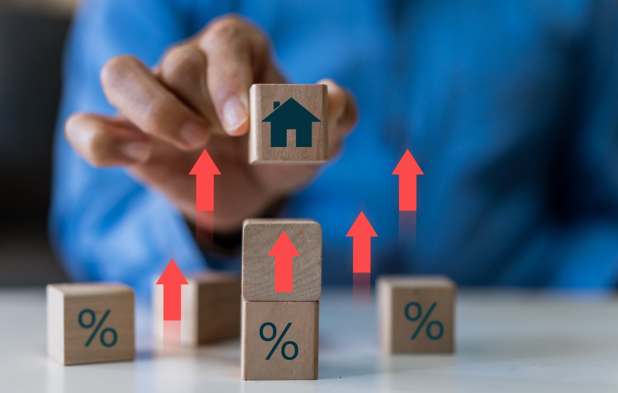 Businessman hold house with percentage, concept of real estate market trends, mortgage rates, property investment and housing market analysis